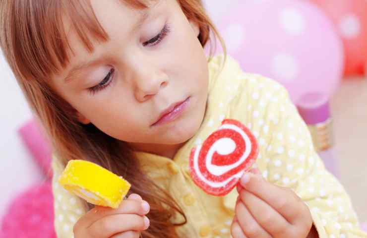 Bambina che mangia dolciumi