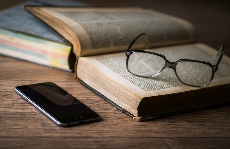 Libro con occhiali e smartphone